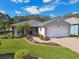 Single-story home with a two-car garage and landscaped yard at 11411 Turtle Dove Pl, New Port Richey, FL 34654