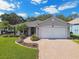 Single-story home with landscaped yard, paver driveway and two-car garage at 11411 Turtle Dove Pl, New Port Richey, FL 34654