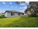 Gray house exterior with screened patio and green lawn at 11411 Turtle Dove Pl, New Port Richey, FL 34654