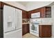 Well-equipped kitchen featuring white appliances and dark wood cabinetry at 11411 Turtle Dove Pl, New Port Richey, FL 34654