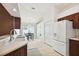 Kitchen with wood cabinets, white appliances, and a dining area view at 11411 Turtle Dove Pl, New Port Richey, FL 34654