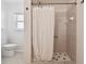 Walk-in shower with white curtain and tile surround at 11411 Turtle Dove Pl, New Port Richey, FL 34654