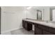 Double vanity bathroom with dark brown cabinets and a large mirror at 12332 Harris Hawk Rd, Weeki Wachee, FL 34614