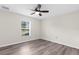 Bright bedroom with ceiling fan and grey laminate floors at 12332 Harris Hawk Rd, Weeki Wachee, FL 34614