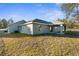 Gray house exterior with covered patio and grassy backyard at 12332 Harris Hawk Rd, Weeki Wachee, FL 34614