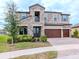 Two-story house with stone accents and a three-car garage at 12795 Fisherville Way, Riverview, FL 33579