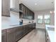 Sleek kitchen with dark cabinetry, white subway tile, and hardwood floors at 12795 Fisherville Way, Riverview, FL 33579