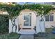 Inviting front entrance with an arched entryway covered in lush vines at 14157 Feather Sound Dr, Clearwater, FL 33762