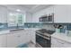 Modern kitchen with stainless steel appliances and white cabinets at 147 Bluff View Dr # 106, Belleair Bluffs, FL 33770