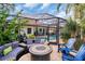 Relaxing patio with fire pit and seating area, overlooking the pool at 1879 Nuthatch Way, Palm Harbor, FL 34683