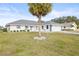 White single story home with gray roof, landscaping, and palm trees at 2024 N Pebble Beach Blvd, Sun City Center, FL 33573