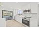 Updated kitchen with white cabinets, stainless steel appliances and view to backyard at 2024 N Pebble Beach Blvd, Sun City Center, FL 33573