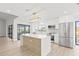 Modern kitchen with island, stainless steel appliances, and access to a patio at 2024 N Pebble Beach Blvd, Sun City Center, FL 33573
