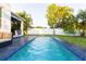 Modern rectangular pool with blue tile accents and ample lounge space at 2246 Fiesta Dr, Sarasota, FL 34231
