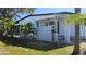 White single-wide mobile home with covered porch and landscaped yard at 27466 Us Highway 19 N # 97, Clearwater, FL 33761