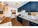 Modern kitchen with navy blue cabinets, granite counters, and stainless steel appliances at 2883 16Th Ave N, St Petersburg, FL 33713