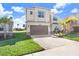 Two story house with a brown garage door and lush landscaping at 3278 Woodland Brook Way, Wesley Chapel, FL 33543