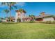 Community clubhouse with palm trees and grassy area at 35980 Morse Willow Ct, Zephyrhills, FL 33541