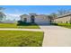 Single-story home with attached garage and landscaped lawn at 35980 Morse Willow Ct, Zephyrhills, FL 33541