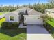 One-story home with attached garage, landscaping, and a paved driveway at 35980 Morse Willow Ct, Zephyrhills, FL 33541