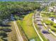 Aerial view of neighborhood with pond, roads, and homes at 35980 Morse Willow Ct, Zephyrhills, FL 33541