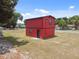 Red two-story house with black trim, located on a grassy lot at 38250 13Th Ave, Zephyrhills, FL 33542