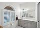 Elegant bathroom with gray cabinets, white quartz countertops, and an arched window at 4687 Alisa Ne Cir, St Petersburg, FL 33703