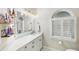 Bright bathroom boasts white cabinets, quartz countertops, and a large mirror at 4687 Alisa Ne Cir, St Petersburg, FL 33703