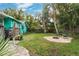 Landscaped backyard with grassy area and stone fire pit seating at 5107 27Th S Ave, Gulfport, FL 33707