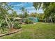 Spacious backyard with grassy lawn, tropical plants, and a fire pit area at 5107 27Th S Ave, Gulfport, FL 33707