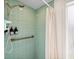 Small shower with light green tiled walls and a white shower curtain at 5107 27Th S Ave, Gulfport, FL 33707