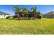 Screened patio, lush landscaping, and expansive grassy yard at 5226 Lake Venice Dr, Wimauma, FL 33598