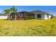 Home exterior view showcasing a large backyard with tropical landscaping at 5226 Lake Venice Dr, Wimauma, FL 33598