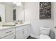 Bathroom boasts a white vanity, gray countertop and decorative art at 5226 Lake Venice Dr, Wimauma, FL 33598