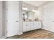 Double vanity bathroom with white cabinets, large mirror, and tile flooring at 5226 Lake Venice Dr, Wimauma, FL 33598