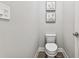 Small powder room with toilet and decorative wall art at 5226 Lake Venice Dr, Wimauma, FL 33598