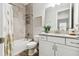 Clean bathroom with white vanity, gray tile and decorative art at 5226 Lake Venice Dr, Wimauma, FL 33598