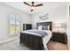 Bright bedroom featuring a large window with plantation shutters and ceiling fan at 5226 Lake Venice Dr, Wimauma, FL 33598