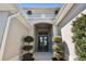 Front entry with double doors, arched entryway, and landscaping at 5226 Lake Venice Dr, Wimauma, FL 33598
