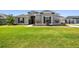 Single-story home with gray exterior, landscaping, and a large yard at 5226 Lake Venice Dr, Wimauma, FL 33598