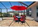Outdoor dining area with red umbrella and seating for six at 5226 Lake Venice Dr, Wimauma, FL 33598