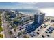 Aerial view of beachfront condo building with pool and ample parking at 5396 Gulf Blvd # 605, St Pete Beach, FL 33706