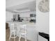 White kitchen with stainless steel appliances and breakfast bar at 5396 Gulf Blvd # 605, St Pete Beach, FL 33706