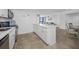 White kitchen with island and stainless steel appliances at 5396 Gulf Blvd # 605, St Pete Beach, FL 33706