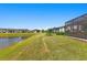 Landscaped backyard with pond and view of homes at 5519 Blue Crush Bnd, Land O Lakes, FL 34638