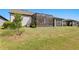 Backyard view of home with screened patio and lawn at 5519 Blue Crush Bnd, Land O Lakes, FL 34638