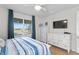 Bedroom with white dresser and large TV, offering natural light at 5519 Blue Crush Bnd, Land O Lakes, FL 34638