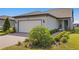 Single-story home with white garage door and landscaped front yard at 5519 Blue Crush Bnd, Land O Lakes, FL 34638