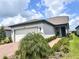 Single-story home with white garage door and landscaped front yard at 5519 Blue Crush Bnd, Land O Lakes, FL 34638
