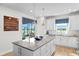 Modern kitchen with island, white cabinets, and access to backyard patio at 5519 Blue Crush Bnd, Land O Lakes, FL 34638